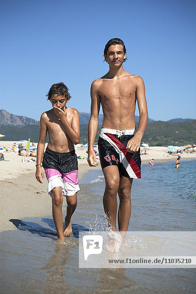 Two brothers walking on beach