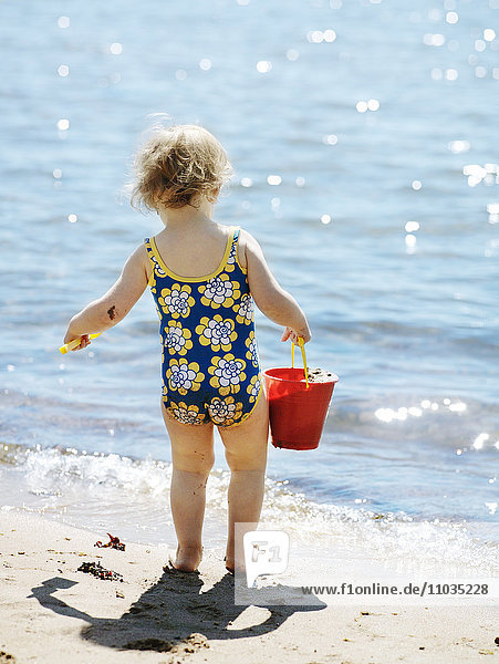 Ein Mädchen spielt am Strand  Schweden.