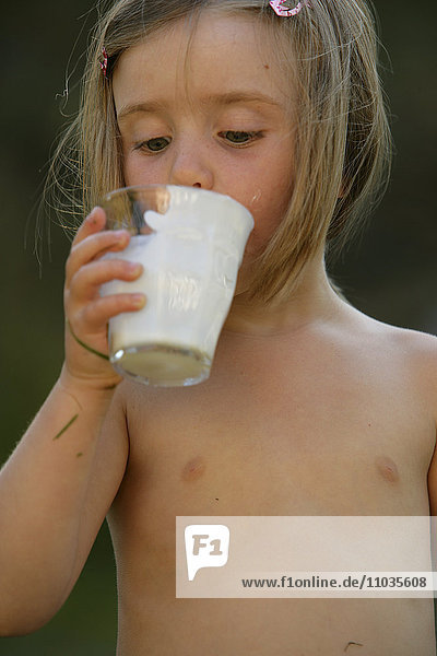 Ein Mädchen trinkt Milch.