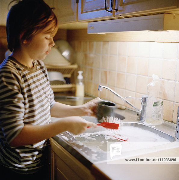 A boy washing up the dishes  Sweden.