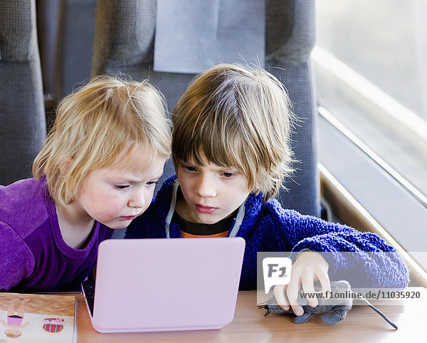 Boy and girl watching film in train