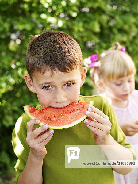 Boy and girl eating watermelon  Sweden.