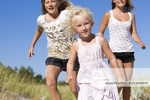 Drei Mädchen laufen am Strand  Schweden.