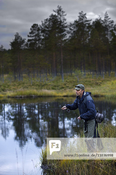 Ein Mann beim Fliegenfischen  Schweden.