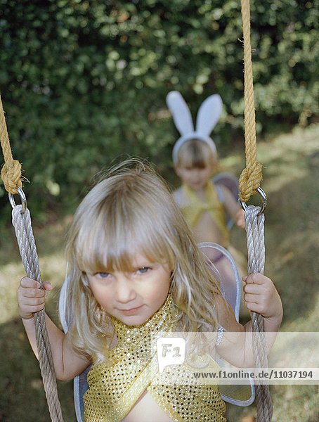 Two dressed up girls by a swing  Sweden.