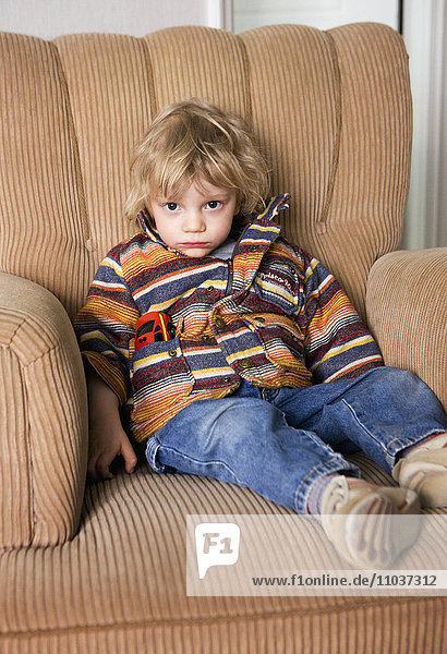 Sulky boy in an armchair  Sweden.