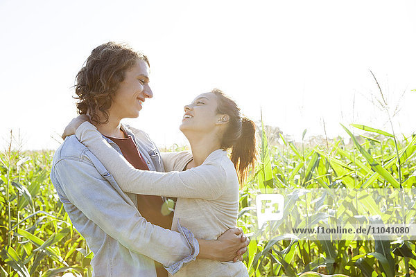 Young couple embracing in field of corn