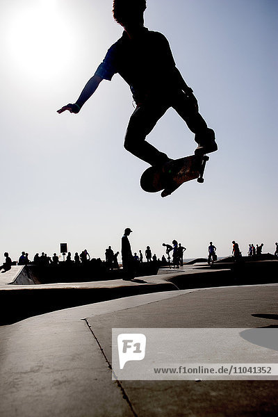 Skateboarder in midair at skate park