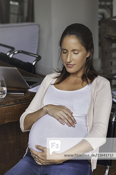 Pregnant woman cradling belly  portrait