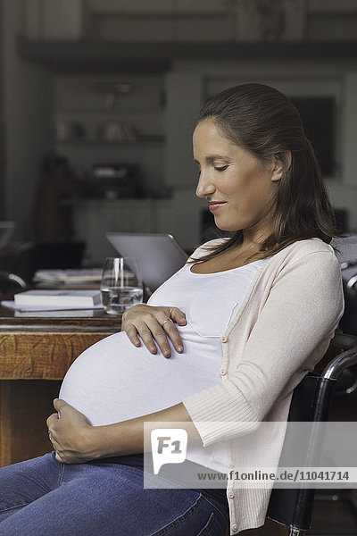 Pregnant woman cradling belly  portrait