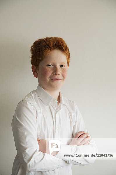 Boy smiling confidently with arms folded  portrait