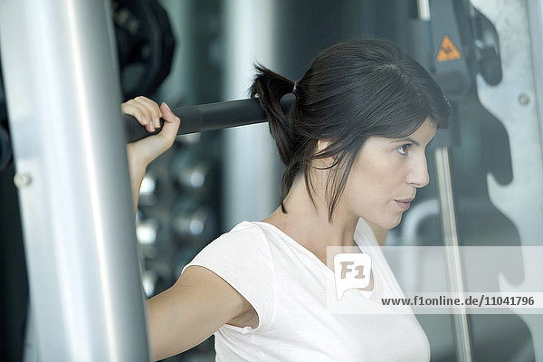 Frau beim Heben von Gewichten im Fitnessstudio