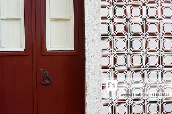 Rote Tür und verzierte Fliesenwand