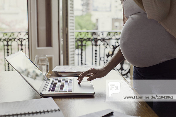 Pregnant woman using laptop computer