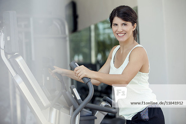 Frau trainiert im Fitnessclub  lächelt fröhlich