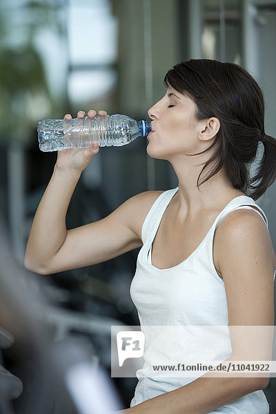 Frau trinkt Wasser nach dem Training