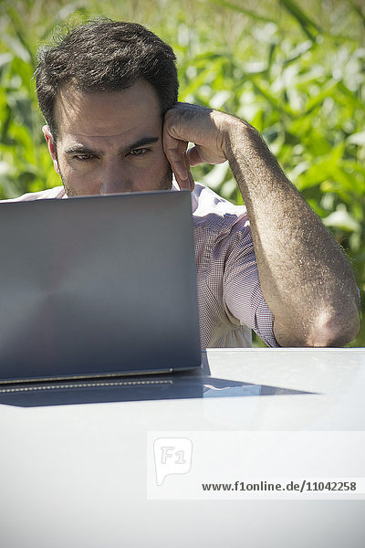 Mann mit Laptop-Computer im Freien