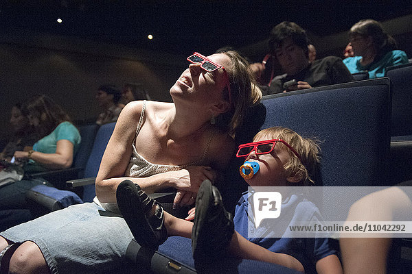 Mutter und Kleinkind-Sohn beim 3-D-Film im Kino