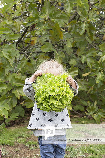 Girl holding head of lettuce