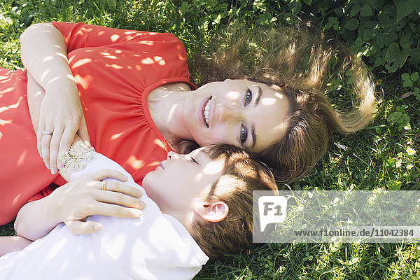 Mutter und Junge auf Gras liegend