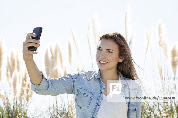 Frau posiert für einen Selfie im Freien