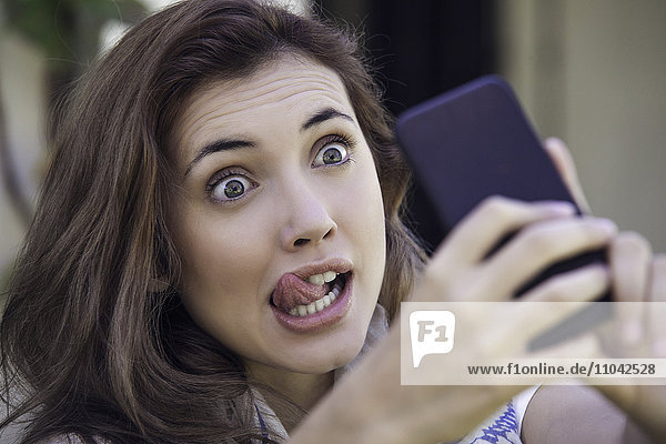 Woman making faces while taking selfie