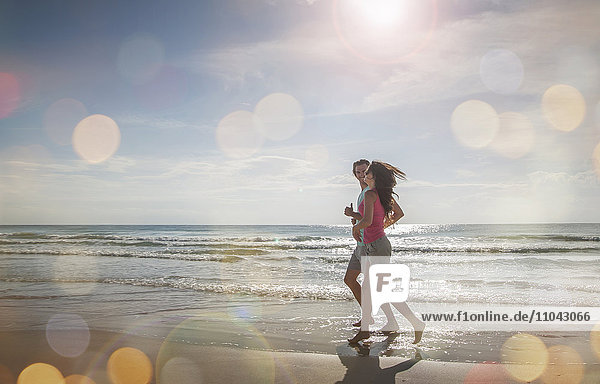 Caucasian couple jogging on beach