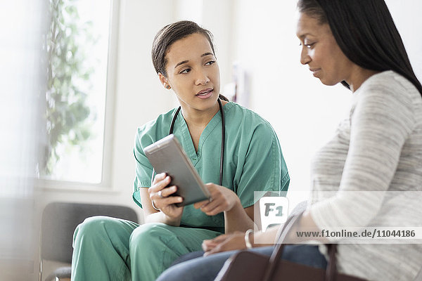 Krankenschwester und Patient mit digitalem Tablet