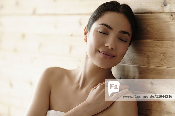 Hispanic woman relaxing in sauna