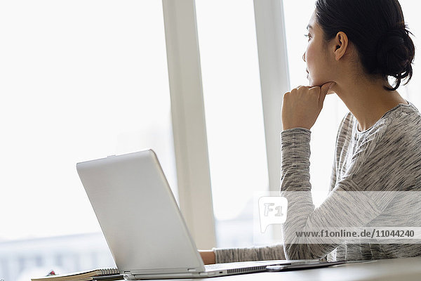 Hispanic woman sitting at laptop