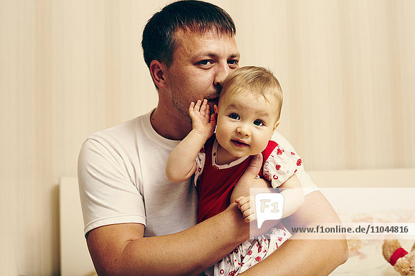 Kaukasischer Vater küsst seine kleine Tochter
