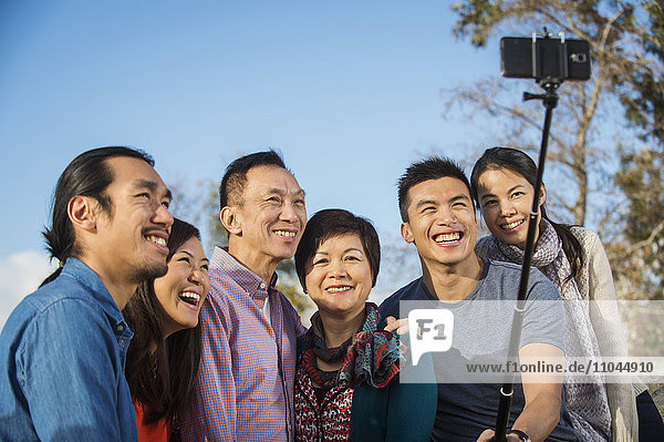 Chinesische Familie beim Fotografieren mit Selfie-Stick