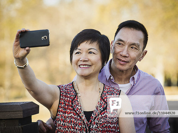 Älteres chinesisches Paar macht Selfie im Freien