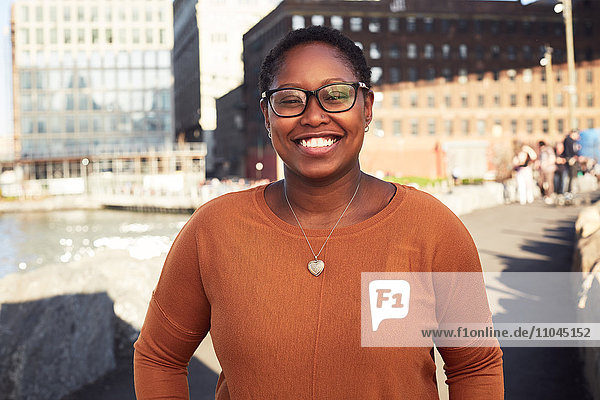 Black woman smiling at waterfront