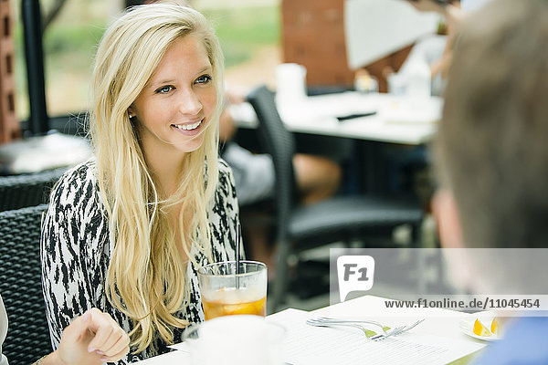 Smiling Caucasian woman sitting at restaurant table