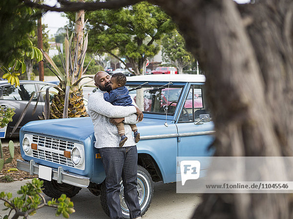 Afroamerikanischer Vater hält Sohn am Lastwagen