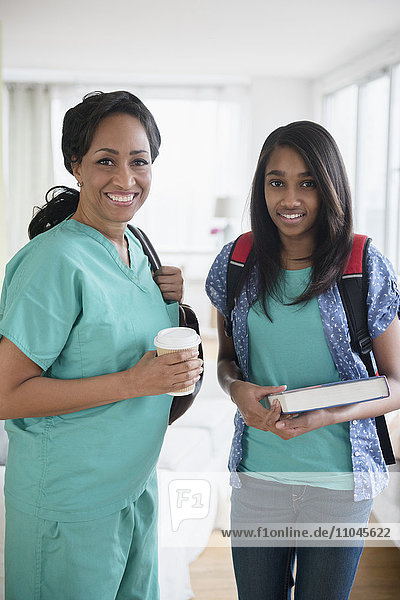 Smiling nurse and daughter leaving house in morning