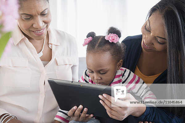 Schwarze Mehrgenerationenfamilie mit digitaler Tafel