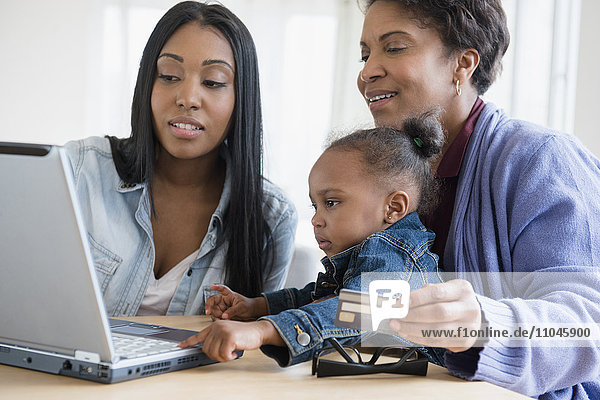 Schwarze Mehrgenerationenfamilie beim Online-Shopping mit dem Laptop