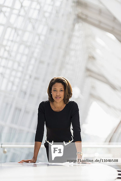 Schwarze Geschäftsfrau lehnt sich über Papierkram Konferenzraum