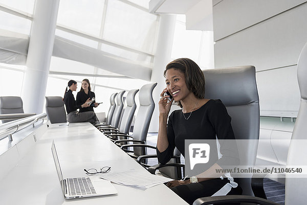 Geschäftsfrau benutzt Mobiltelefon im Konferenzraum