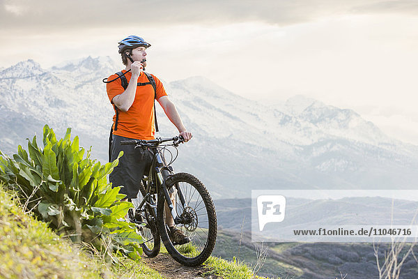 Caucasian man riding mountain bike resting and drinking water