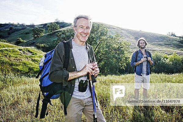 Kaukasische Wanderer stehen im Gras auf einem Berg