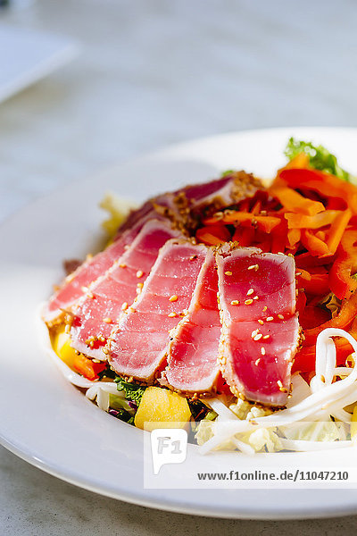 Teller mit geschnittenem Thunfisch und Salat
