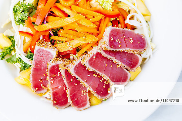 Hochformatige Ansicht von geschnittenem Thunfisch und Salat