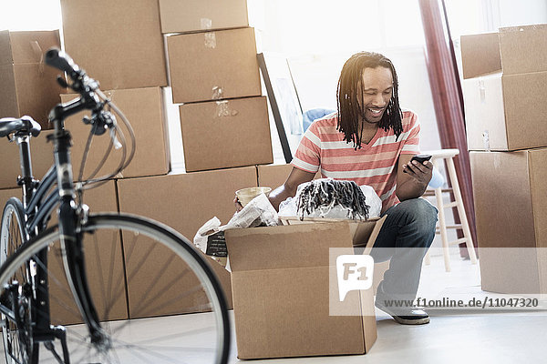 Black man unpacking boxes in new home