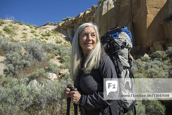 Ältere kaukasische Frau beim Wandern mit Rucksack