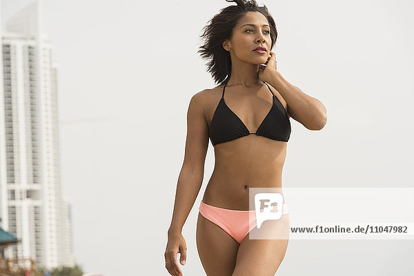 African American woman wearing bikini on beach