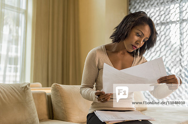 African American businesswoman reading paperwork in hotel lobby