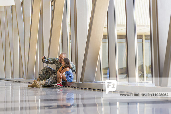 Heimkehrender Soldat macht Selfie mit Tochter am Flughafen